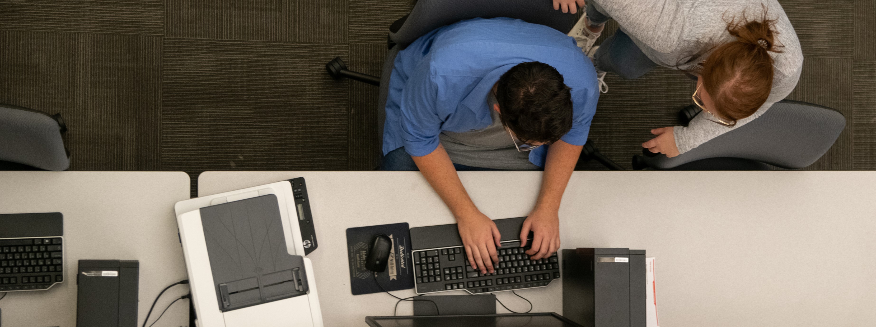 aerial view of a student typing on a computer keyboard