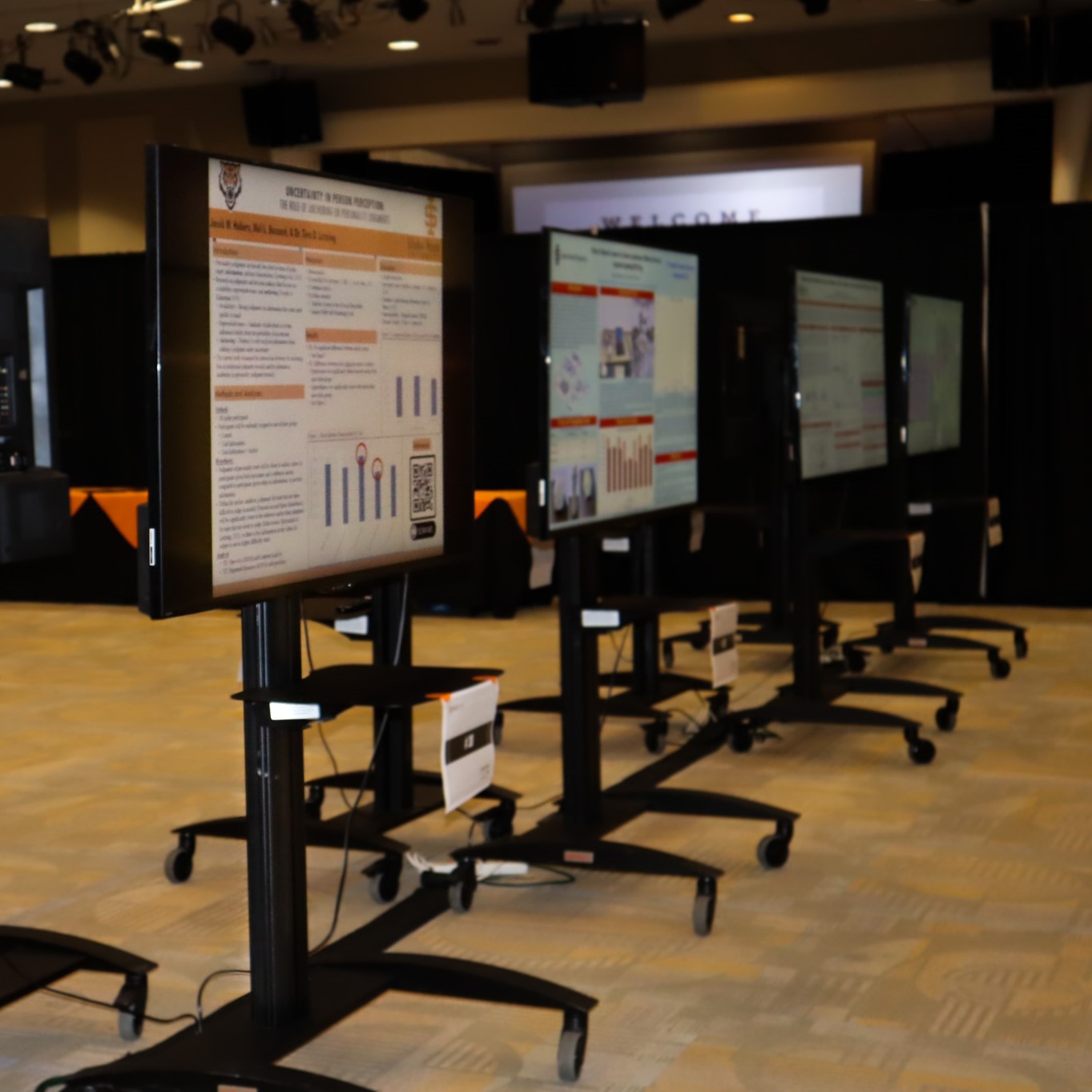 row of TVs displaying GRS student posters