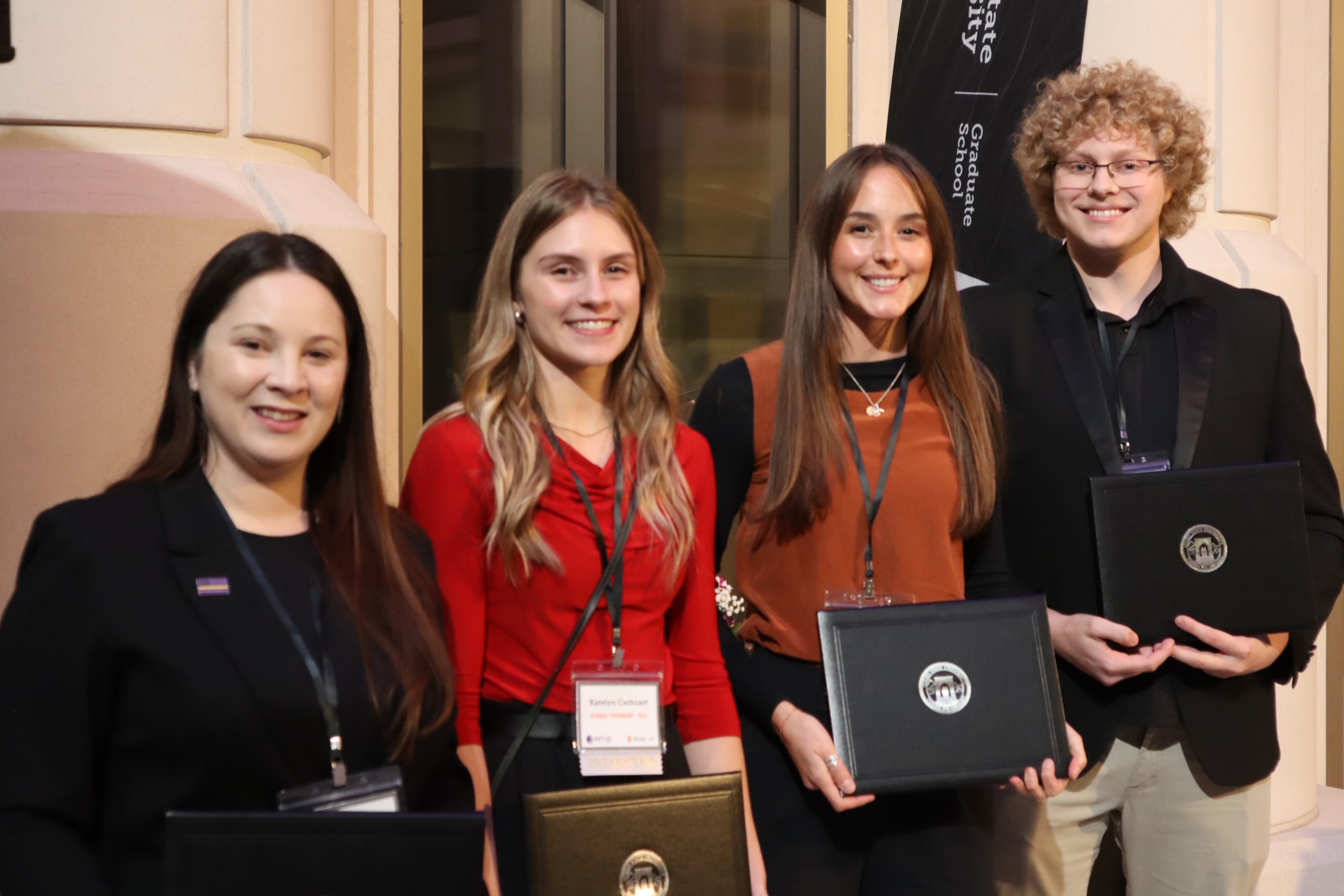 3MT 2025 Winners smile at the camera while holding their award certificates