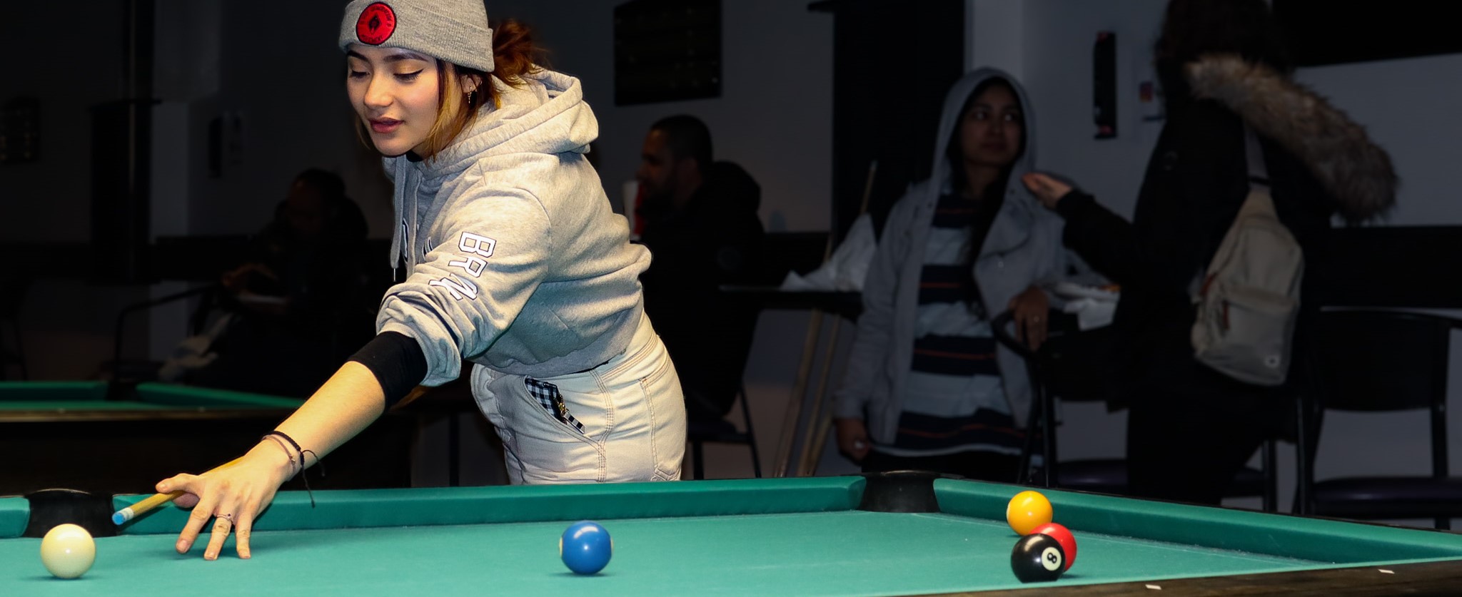 A student playing pool at Late Nights