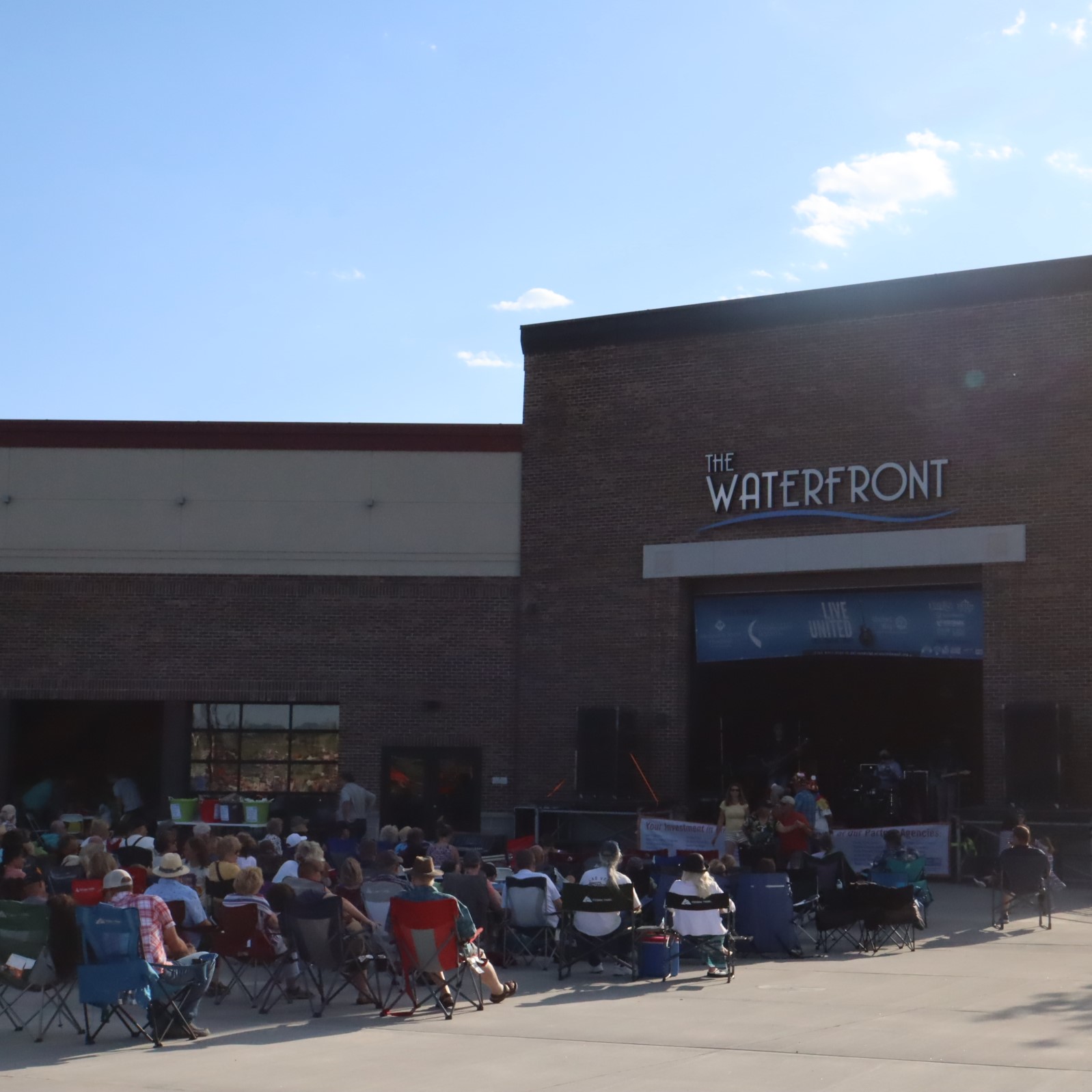 concert goers in front of the Waterfront stage in Idaho Falls listening to a band