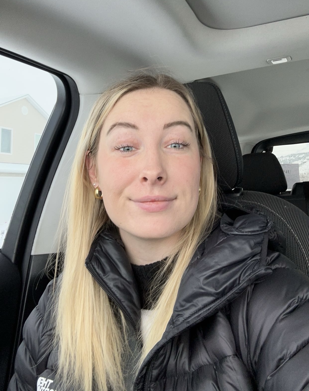 Morgan Frost, a graduate student, smiling in her car