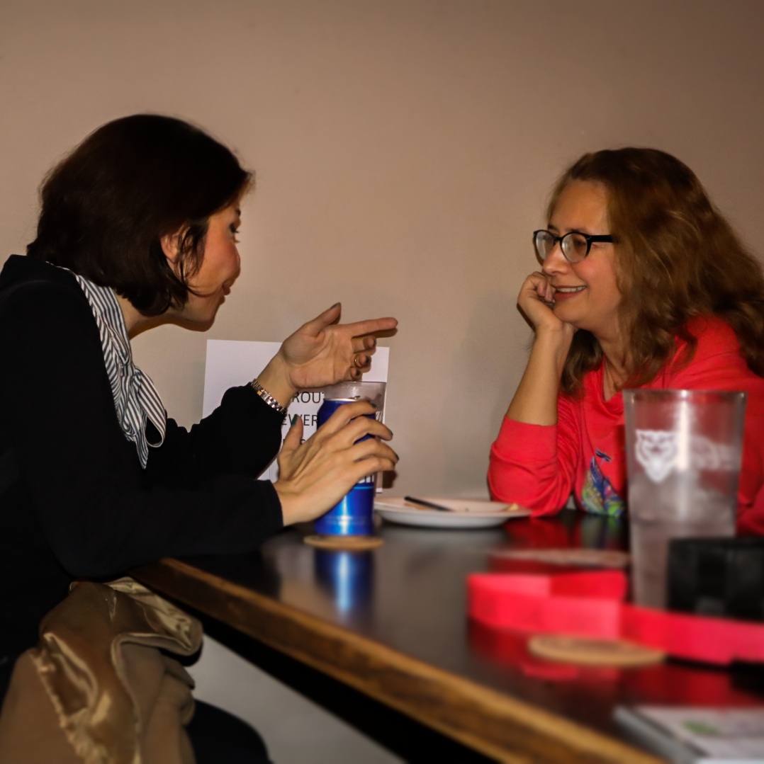 a graduate student and faculty member conversing at late nights