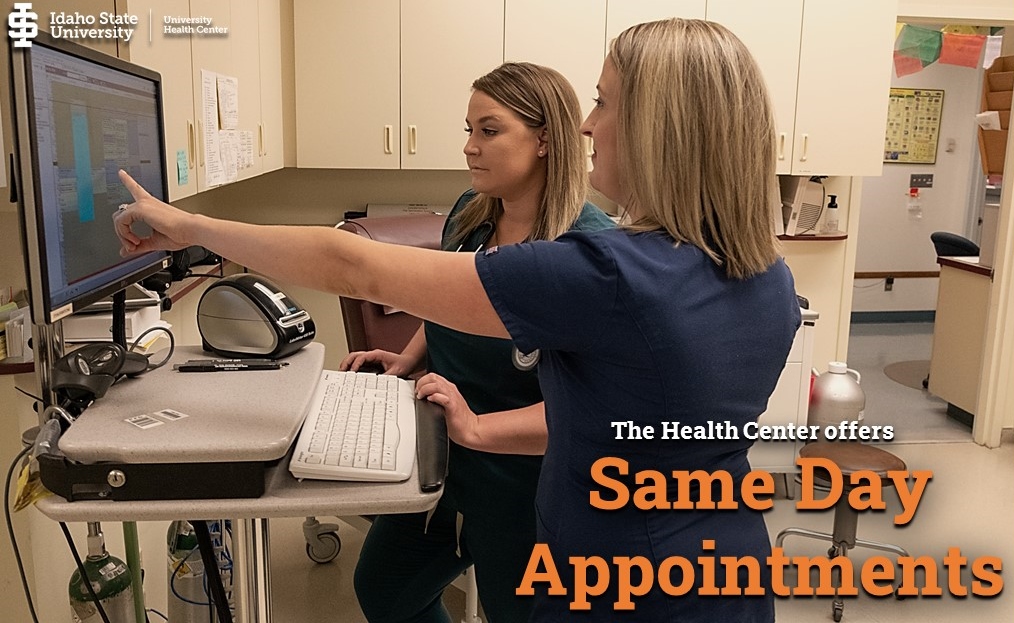 Health Center nurses conferring at a computer station