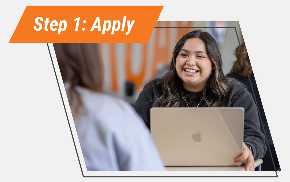 Smiling student seated with a laptop while meeting with a staff member, representing Step 1: Apply to Idaho State University.