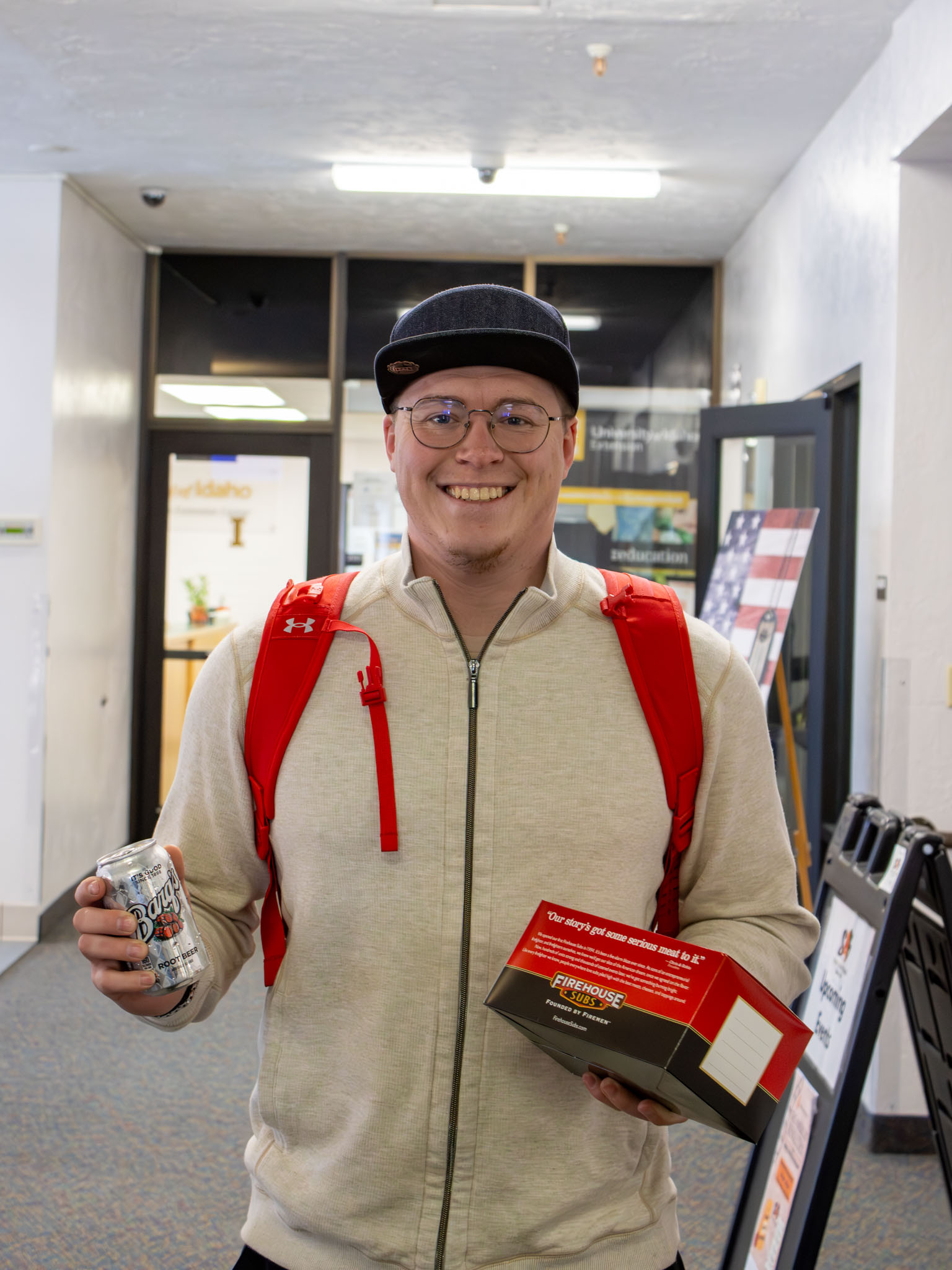 Student at the midterm relief lunch with a boxed lunch from Firehouse Subs