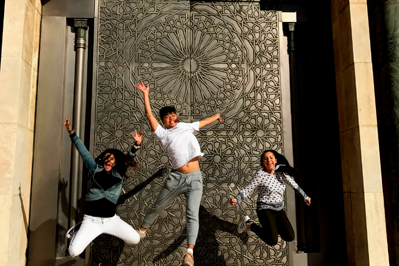 Students jumping in front of door. 