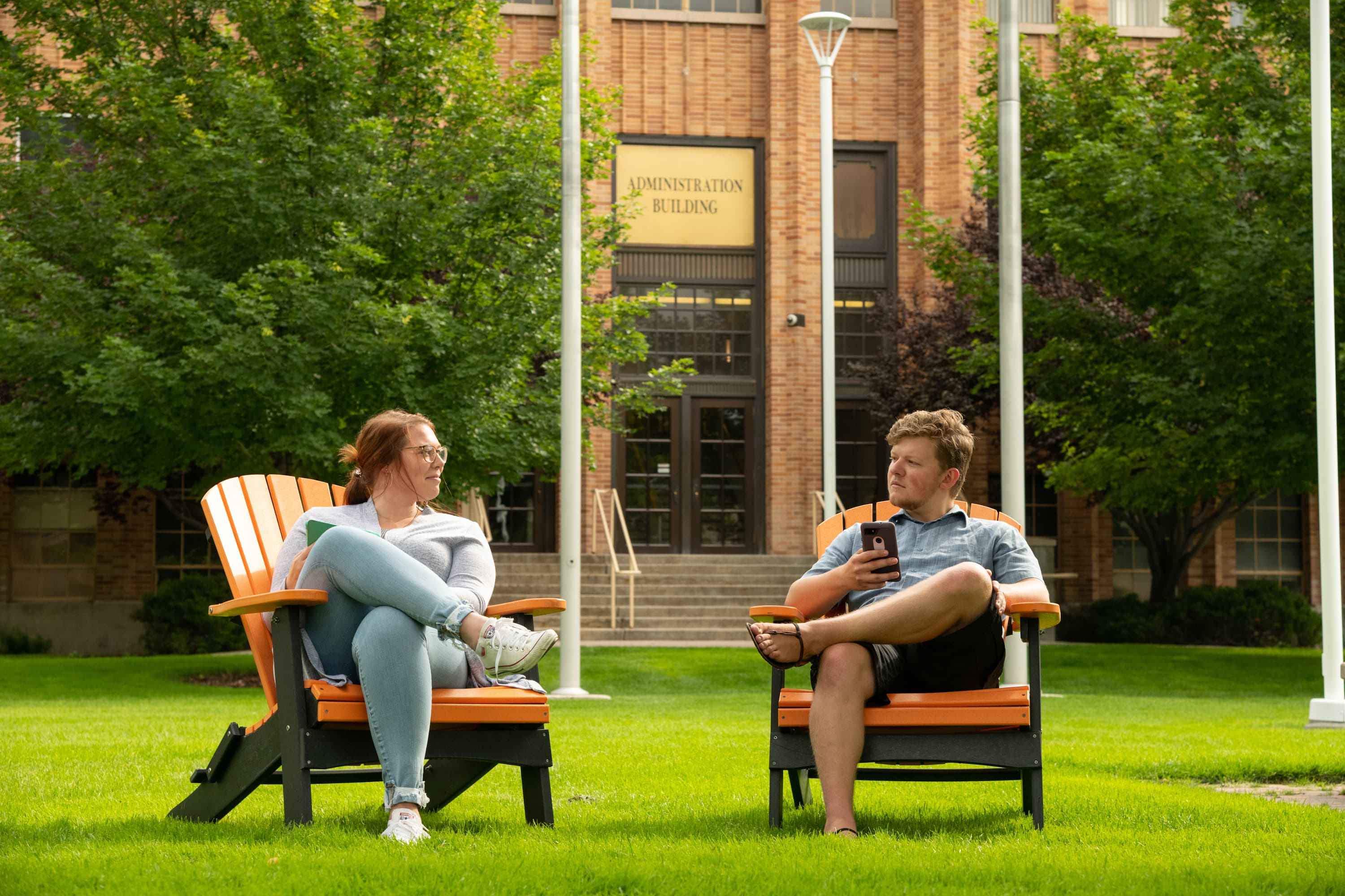 Students talking in lawn chairs on the quad in front of the Administration Building.