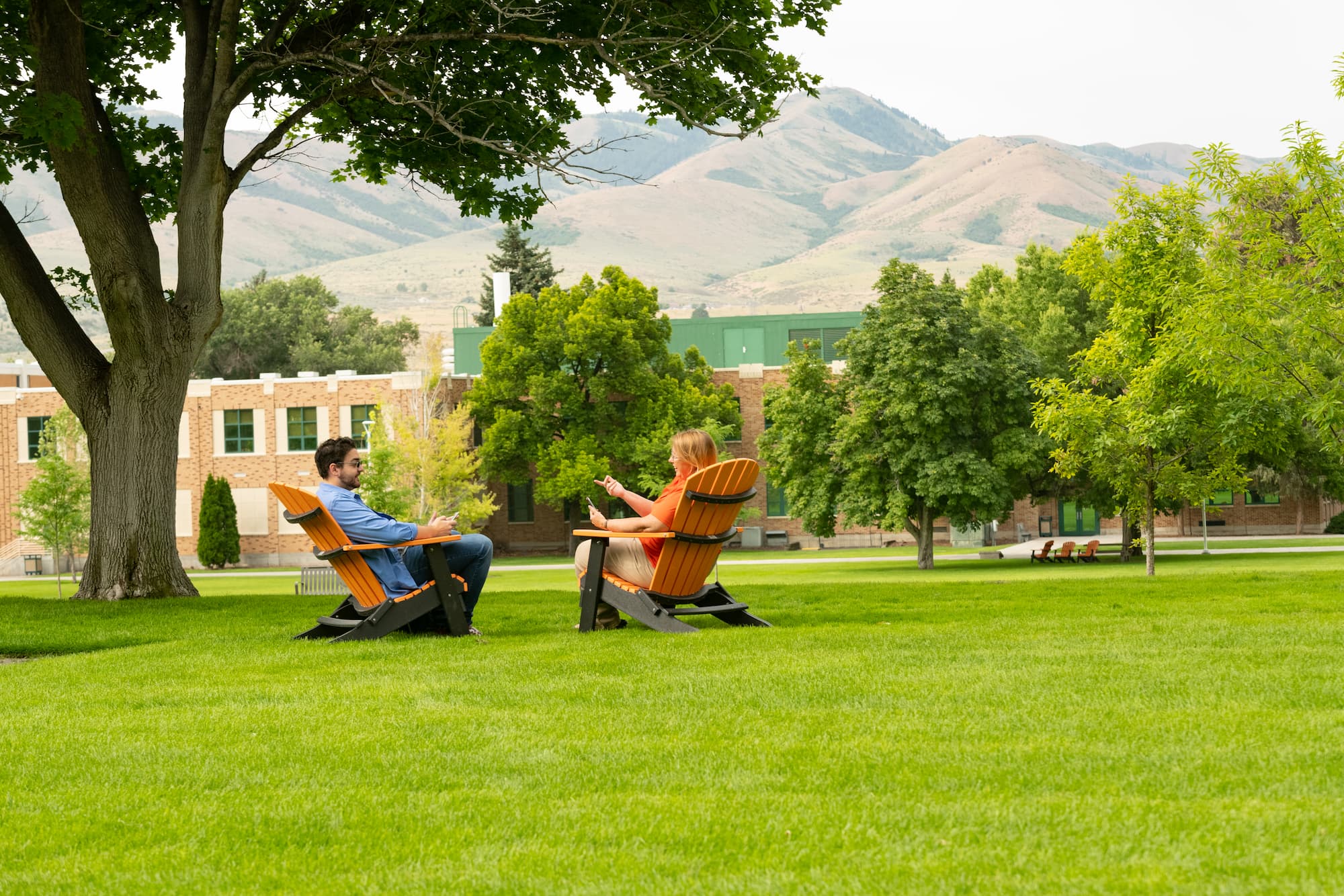 Students talking in lawnchairs on the quad.