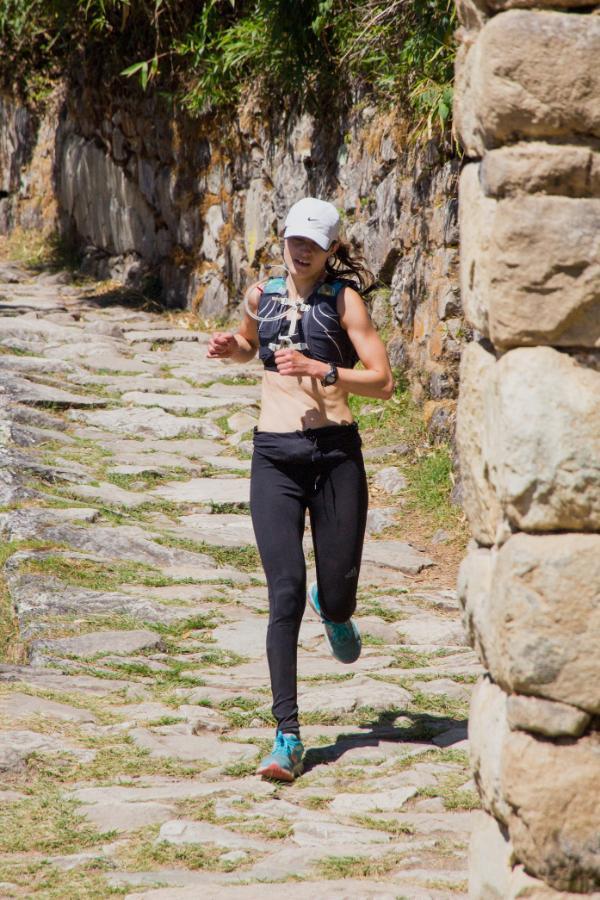 Woman running mountain trail in Peru