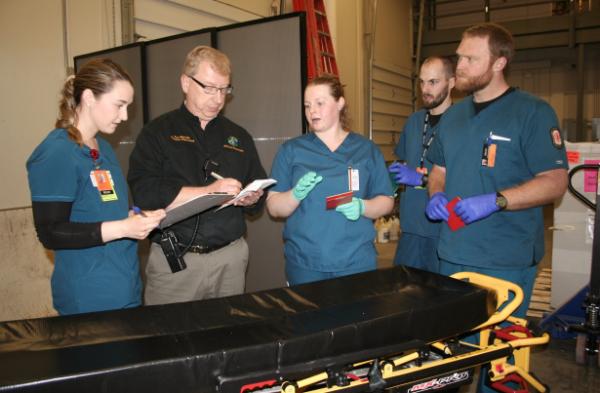 Team standing in line with clipboards to assess patients