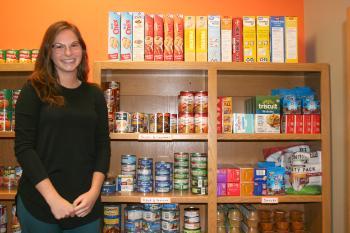 Student standing next to food shelves in Benny's Pantry