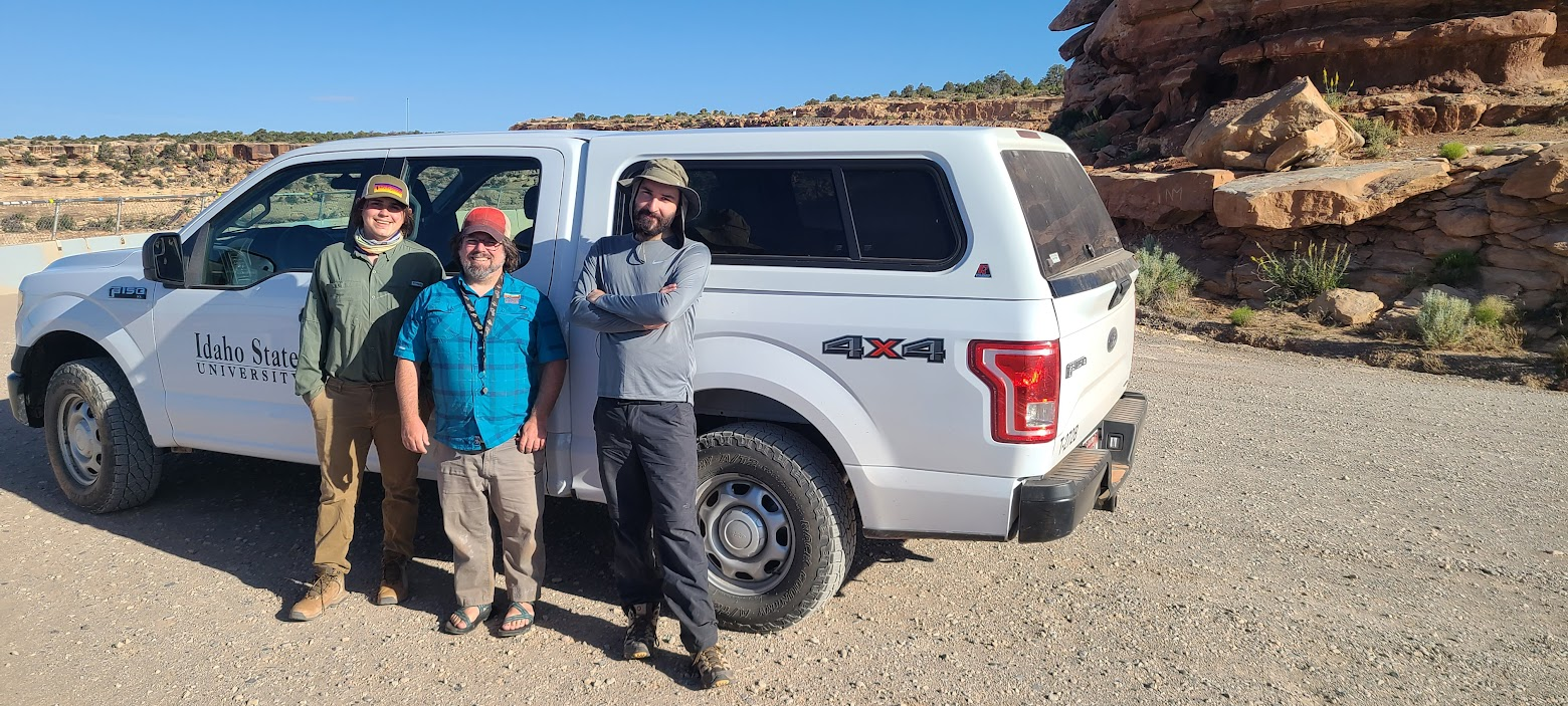 Xavier Jenkins, Rob Gay, and Henry Thomas stand in front of field vehicle.