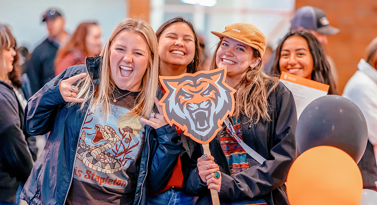 A group of excited students holding the Bengal logo