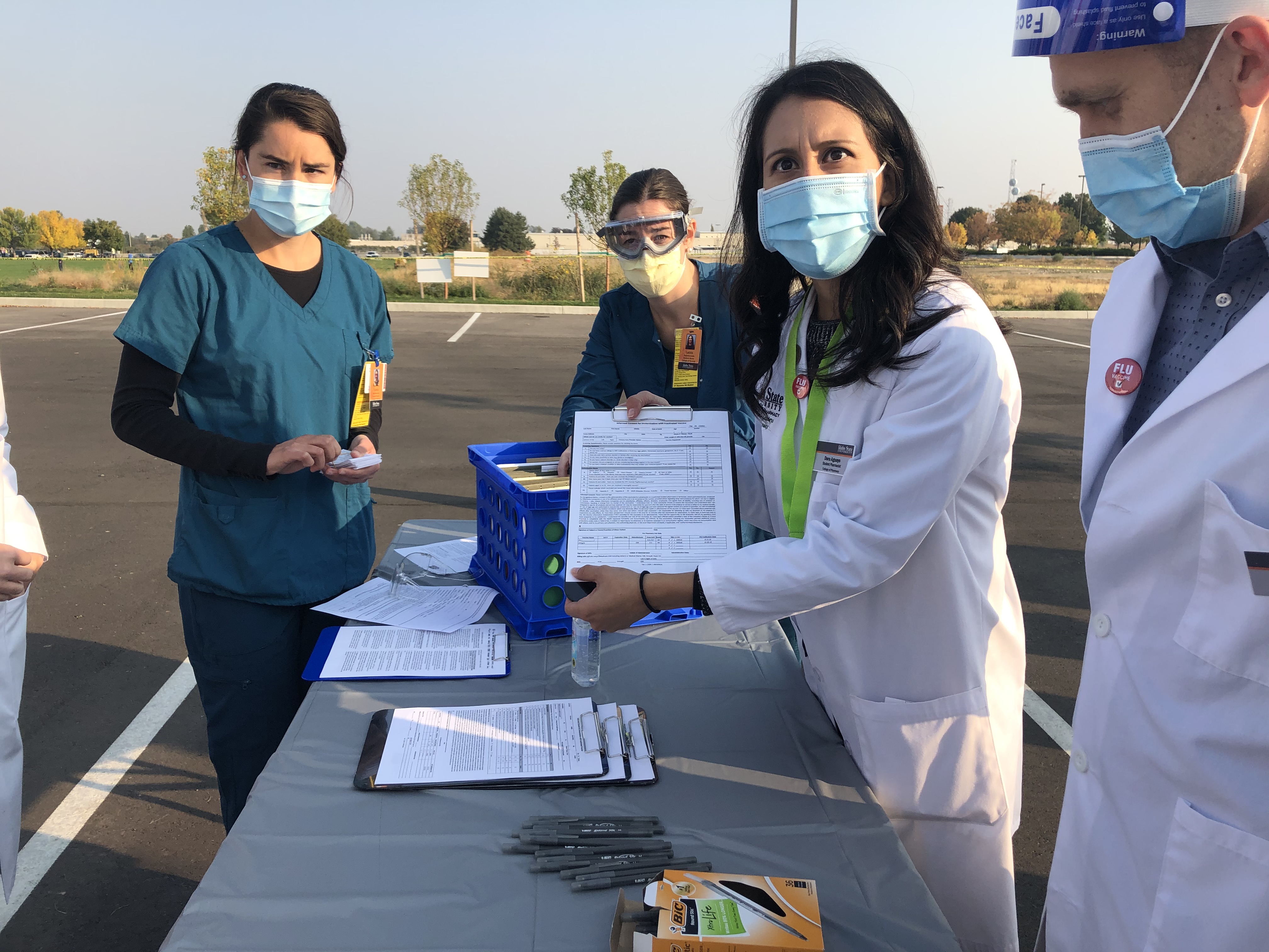Student pharmacists and nurses prepare paperwork during a drive up flu shot clinic