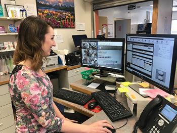 Kori Wittrock, PharmD, uses her computer and a series of cameras to verify prescriptions through Bengal Pharmacy’s dispensing system. Wittrock’s left screen shows live cameras for Council, Challis, and Kendrick.