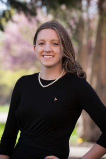 Kristen Morse poses in front of a tree