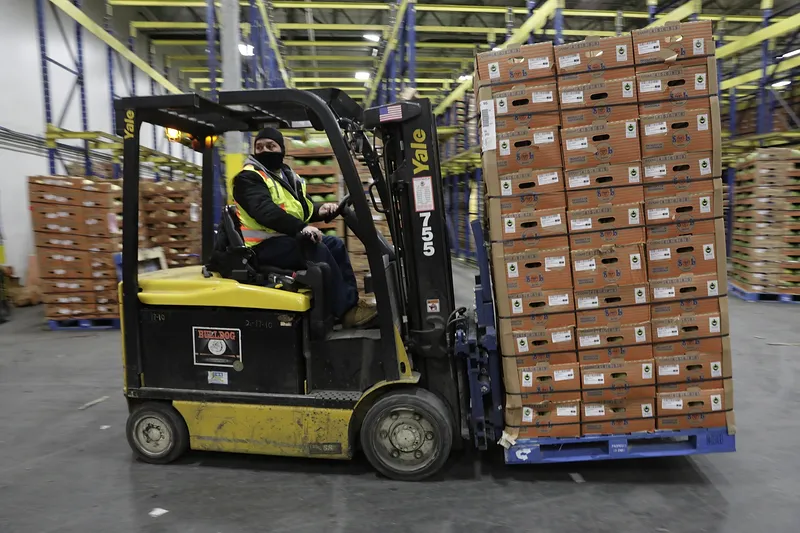 Forklift operator moving a pallet of materials