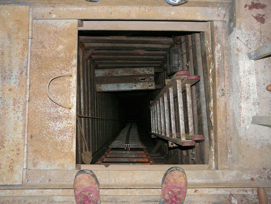 shows a ladder going into a pit, confined space