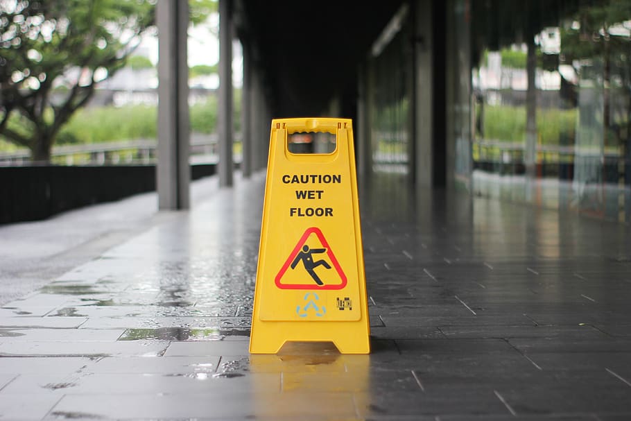 Wet floor caution sign on wet pavement