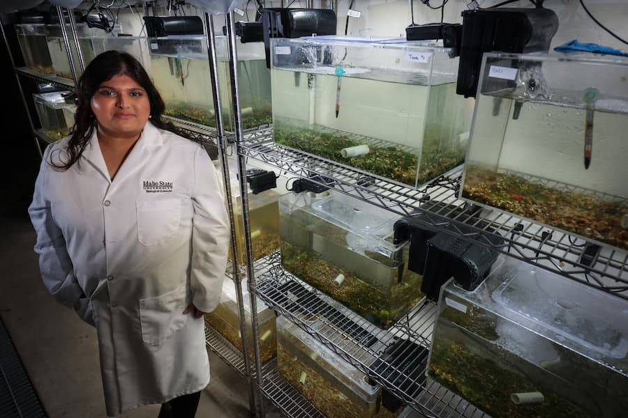 Dr. Devaleena Pradhan standing next to fish tanks