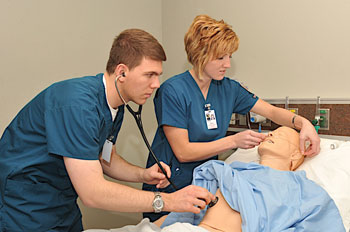 A picture of students with a medi-man mannequin