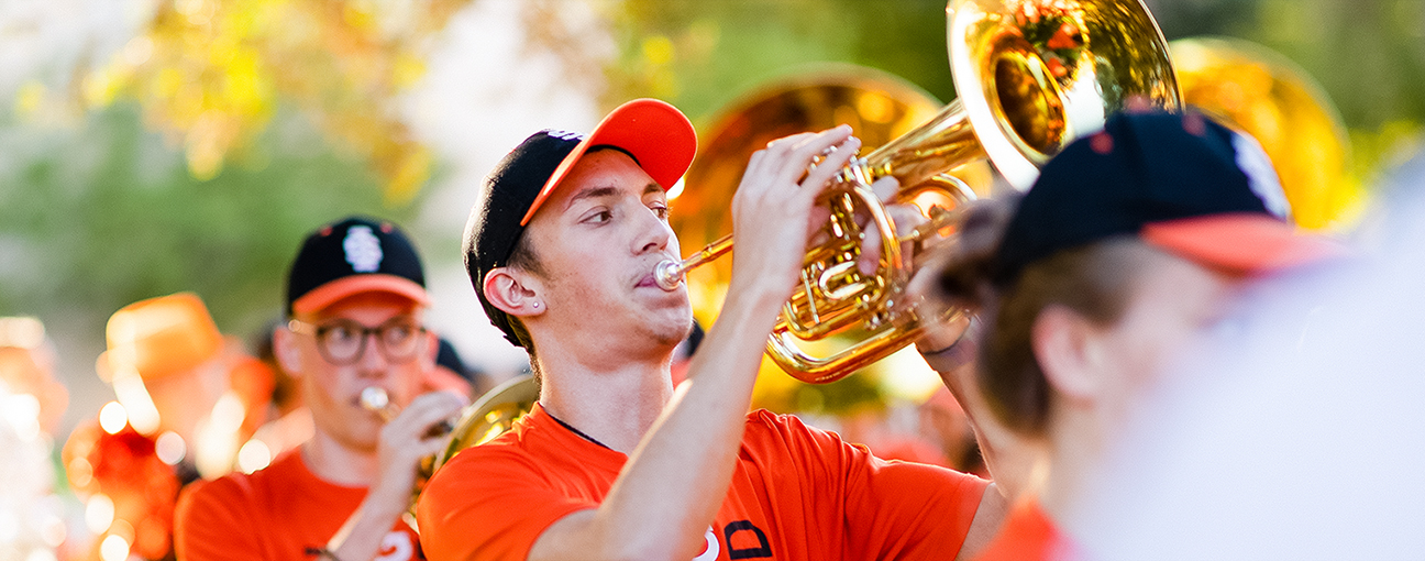 A student in the marching band playing the trumpet.