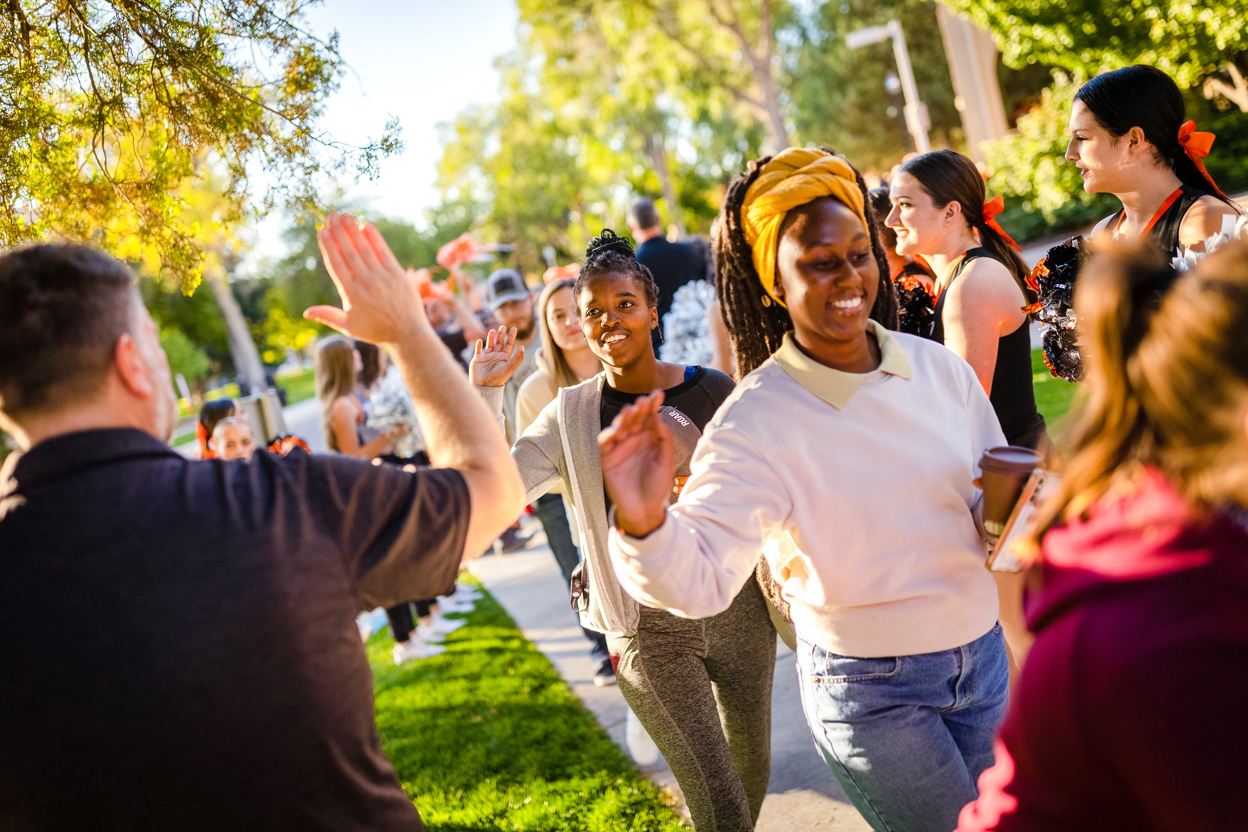 A group of students high-fiving a staff member at an ISU event