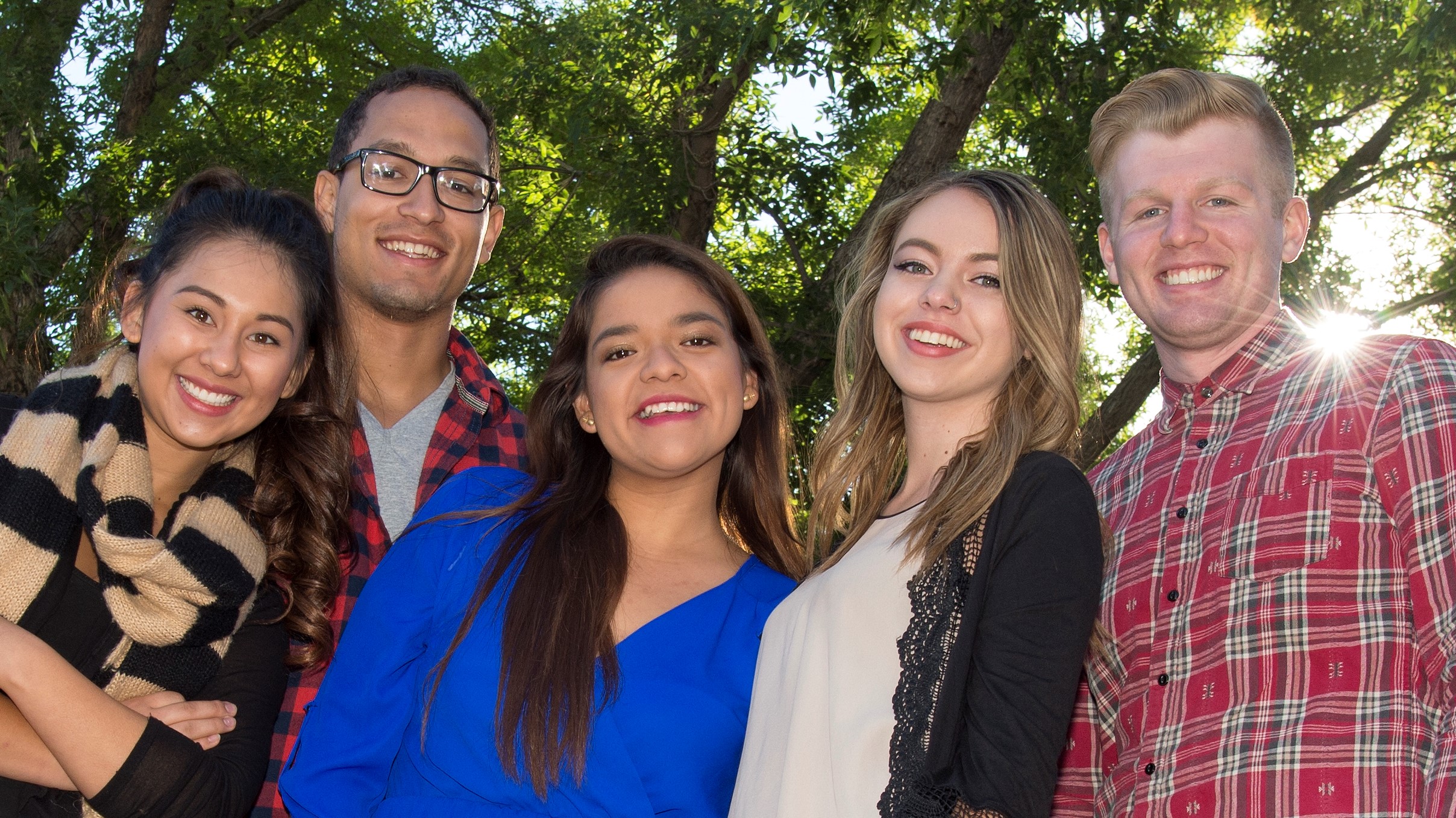 4 students standing in front of a tree