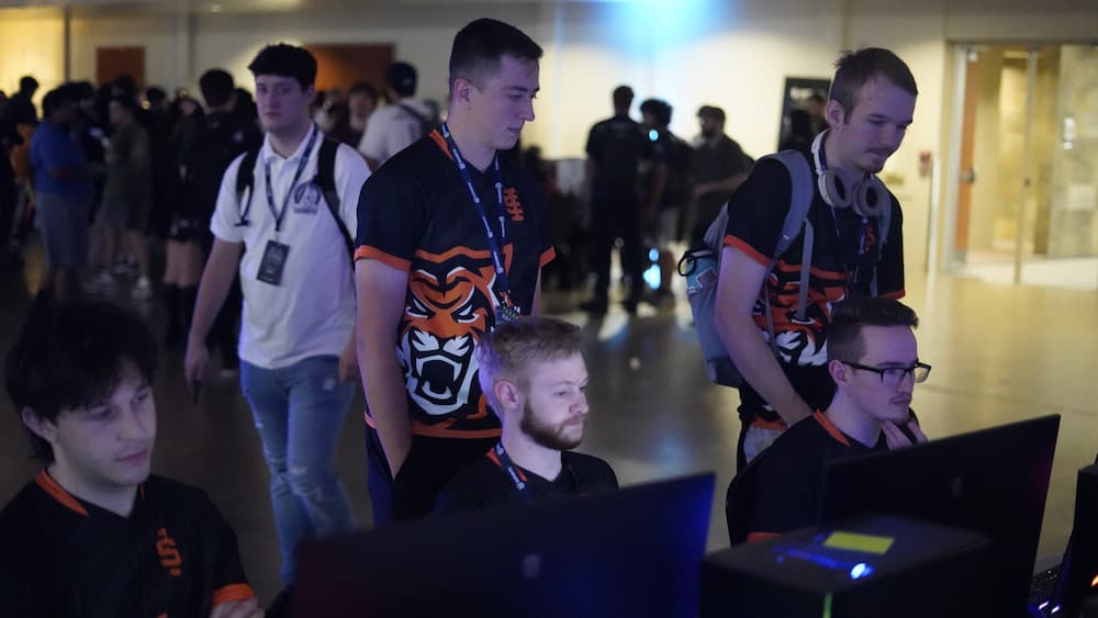 Coach Charles and Ian behind Rocket League team while they set up at the National Championship in Texas