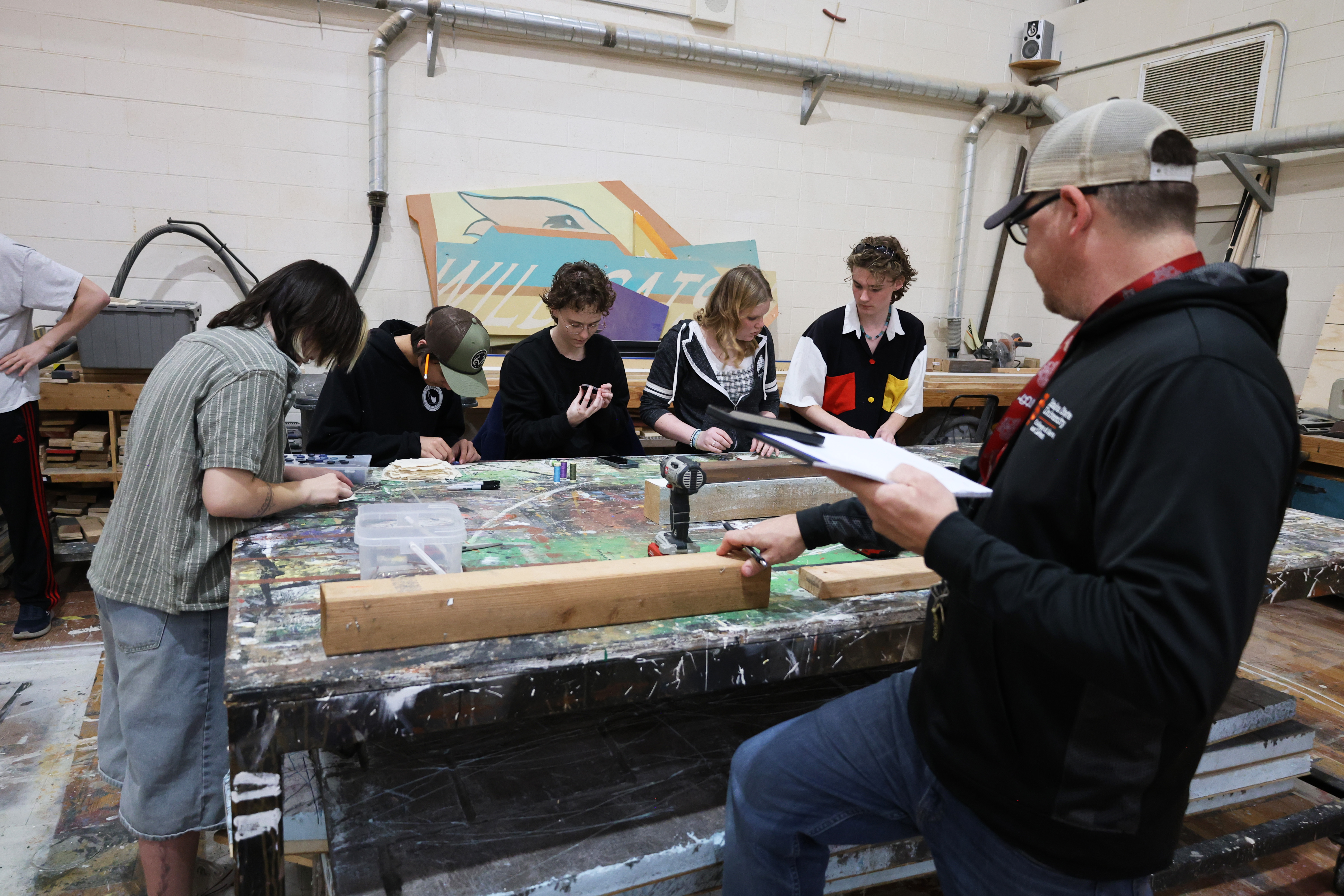 Faculty teaching students in the theatre scene shop