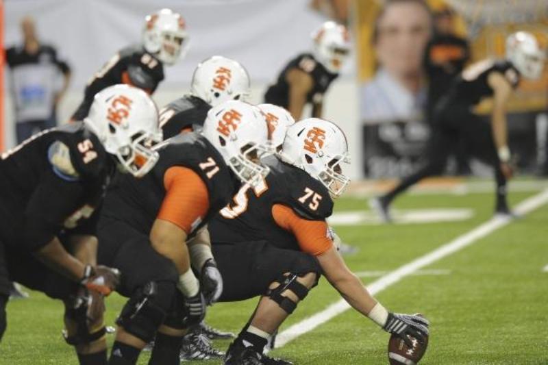 Side view of Offensive line players in ISU black uniforms
