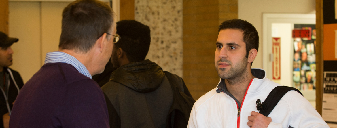 Two men interacting in the College of Business building at Idaho State University.