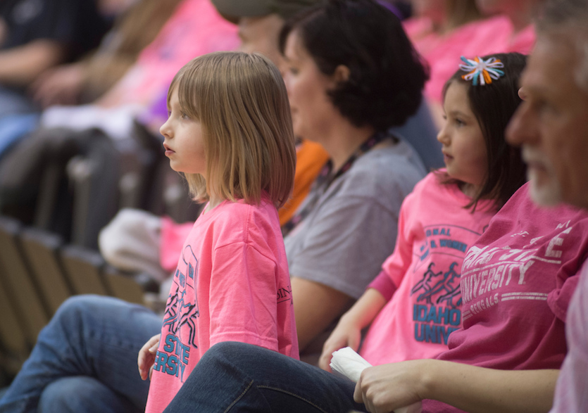 Three girls dressed in pink T-shirts with women in background that were at last year's (2016) event. 