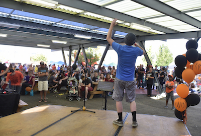 Photo of master of ceremonies speaking in a microphone on stage. 