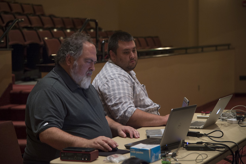 Photo of two technicians working on the installation of new sound system. 