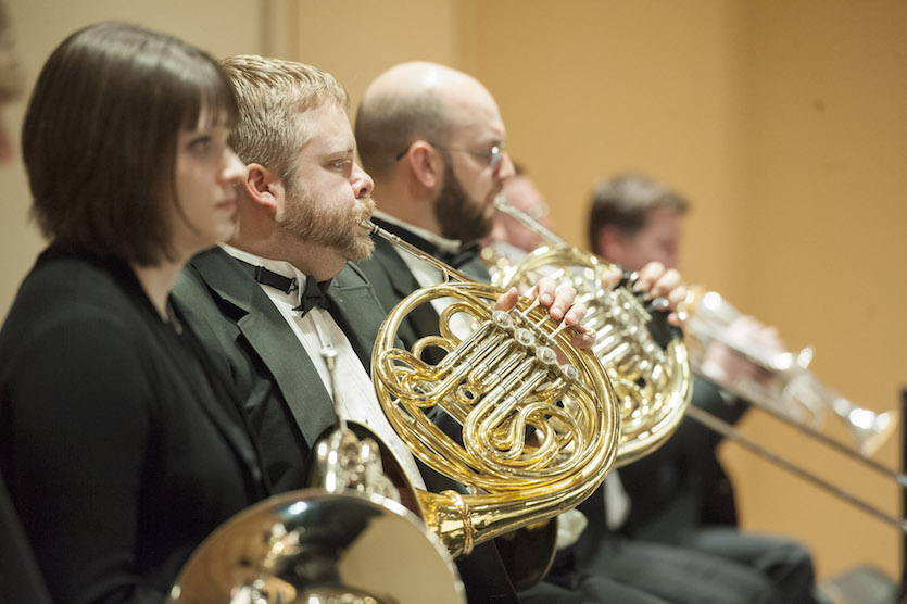 A photo of French horn section of symphony.