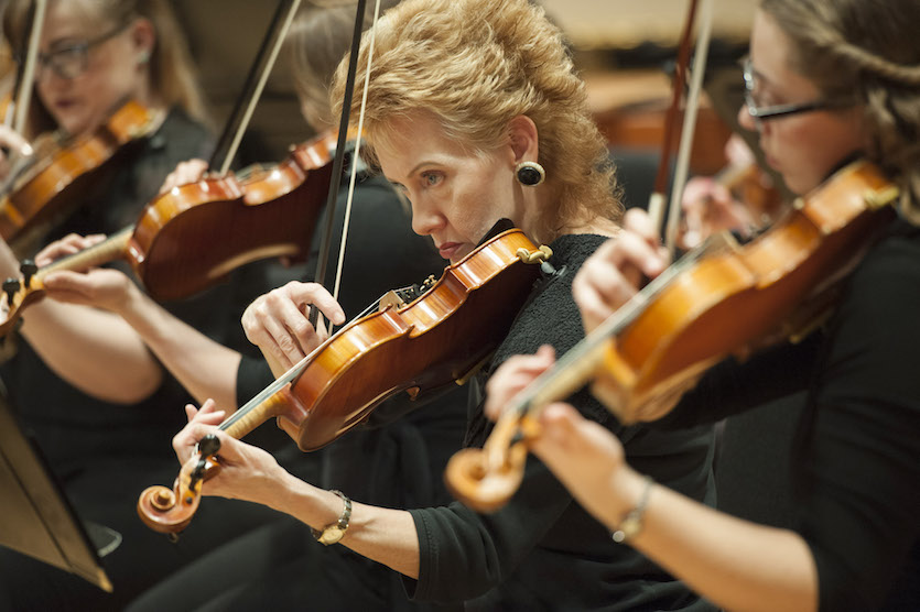 Three symphony volinists playing