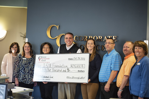 College of Business Employees hold a $25,000 check