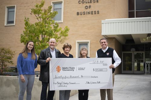 Four people holding a large check