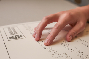 A hand reads braille