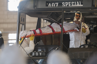 Two first responders extricate a simulated patient from a bus