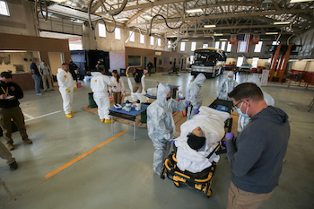 Teams work on a patient in a simulated disaster.