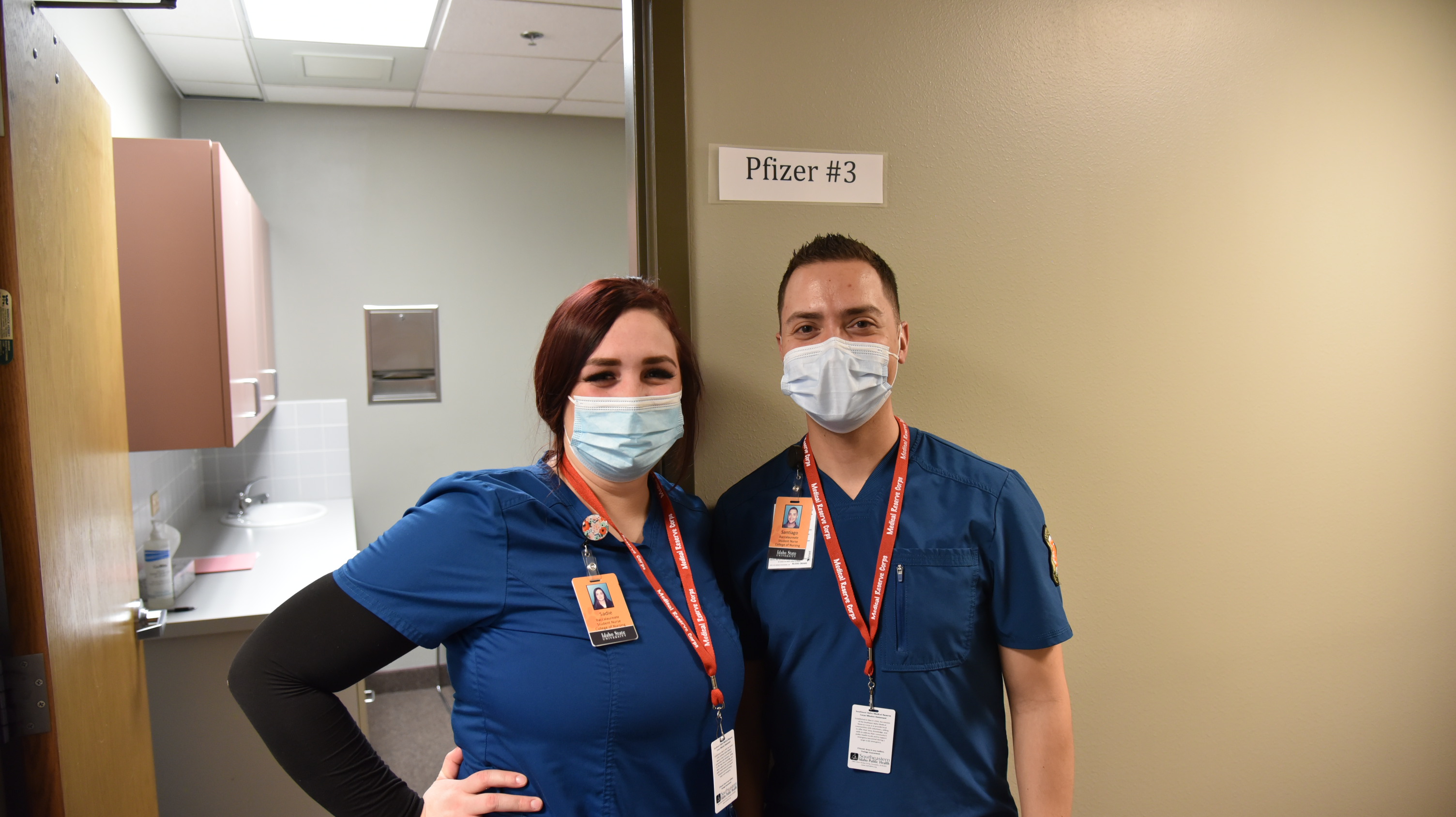 two students preparing to assist with COVID-19 vaccine distribution