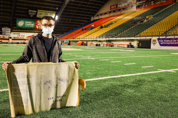 A student holds blueprints for Holt Arena