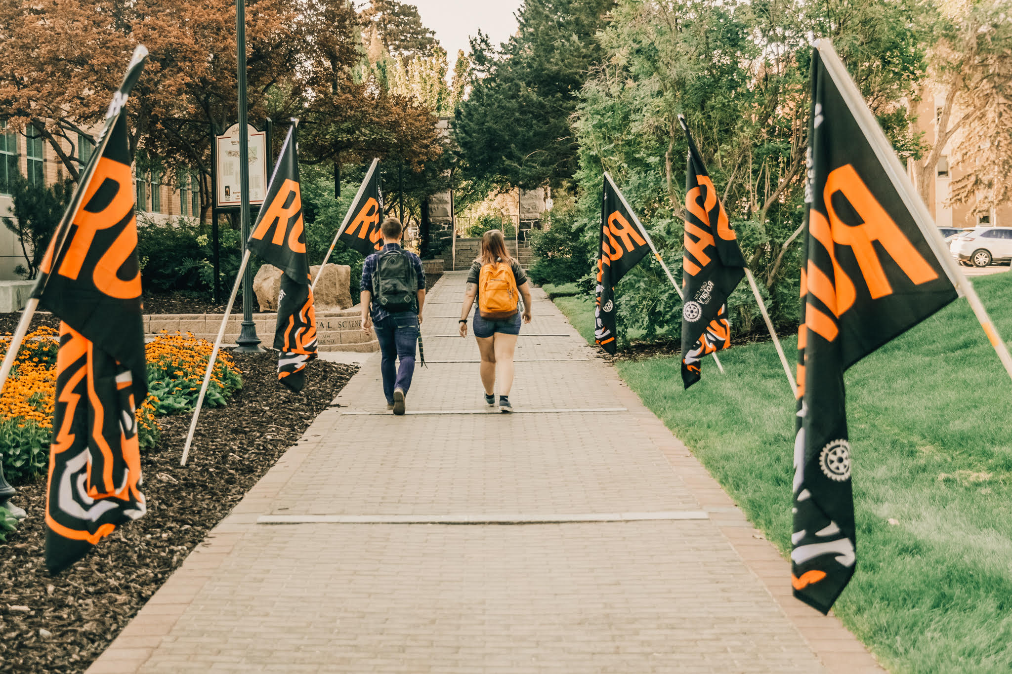 Two students walk across campus in fall