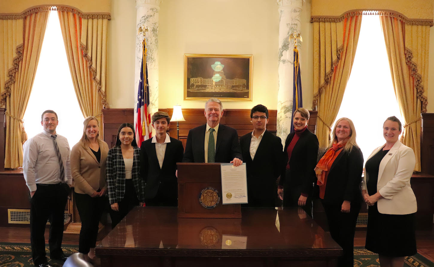 A group of students stand with Governor Brad Little