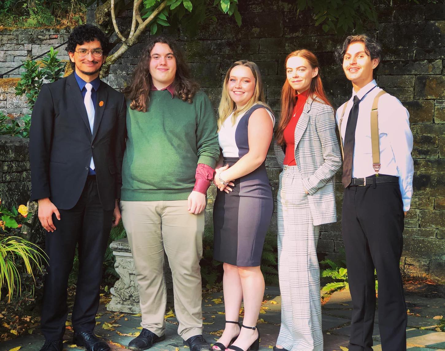 Five debate students pose for a photo