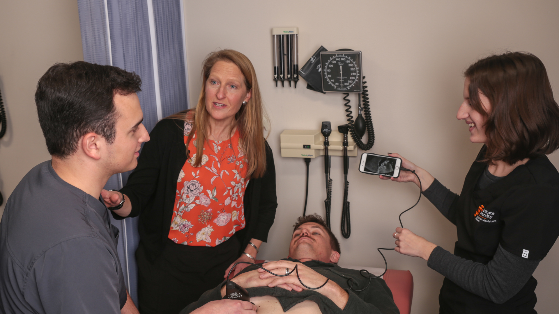 A group of students examine a patient