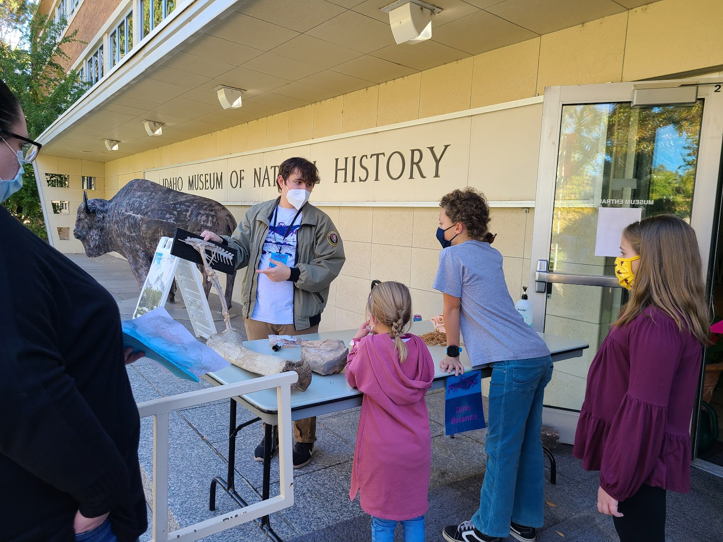 A man shows two children a fossil